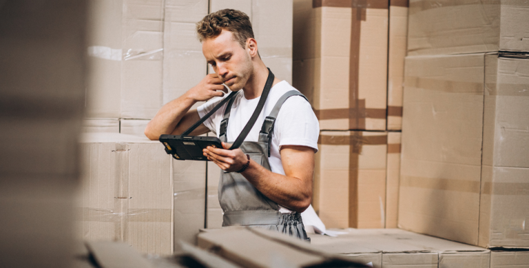 Jovem trabalhando em um armazém com caixas.